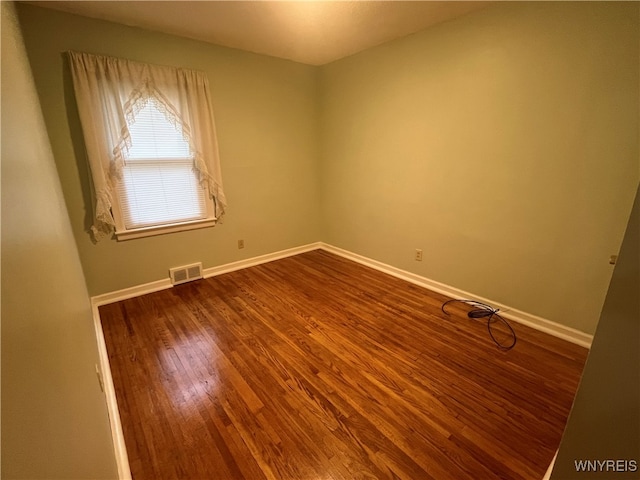 unfurnished room with hardwood / wood-style flooring