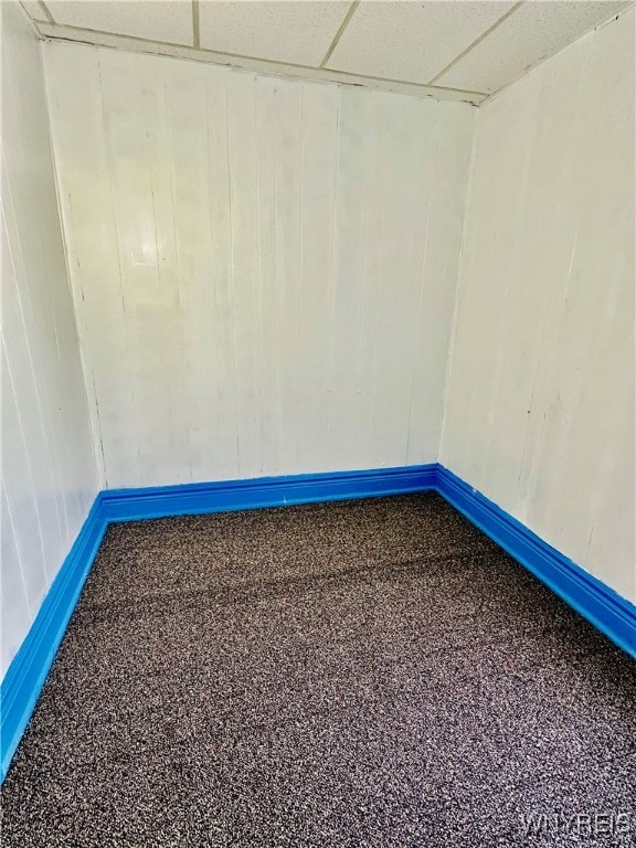 carpeted spare room featuring a drop ceiling