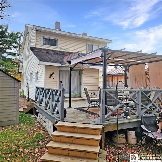 back of property featuring a deck and a pergola