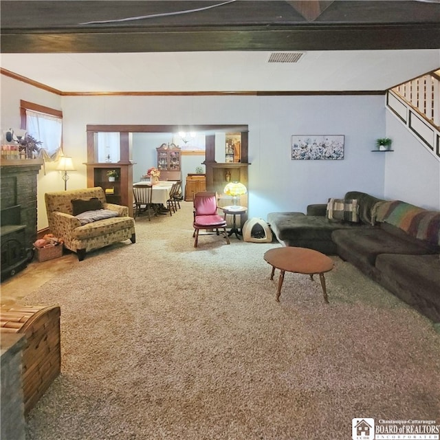 carpeted living room featuring a stone fireplace, ornamental molding, and beamed ceiling