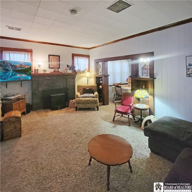 living area featuring a wood stove, carpet floors, wood walls, and crown molding