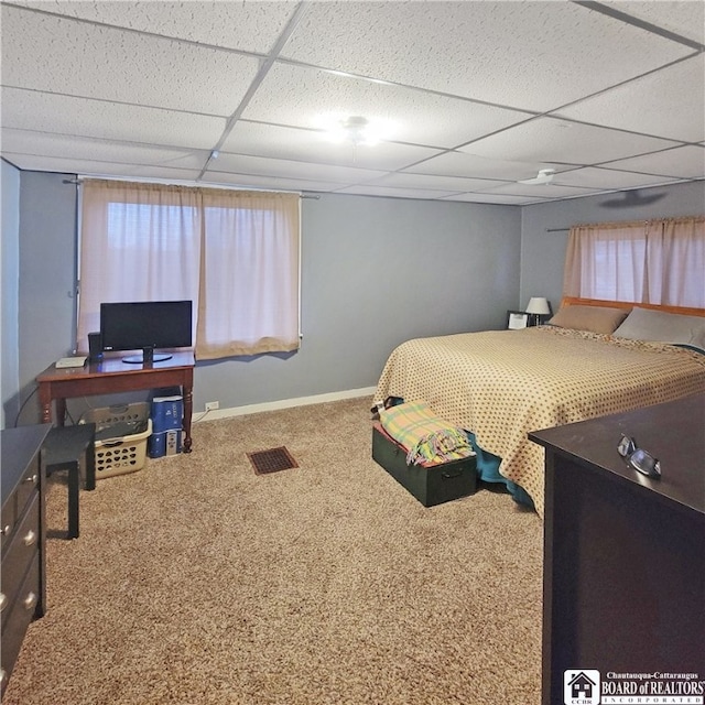 carpeted bedroom with a paneled ceiling