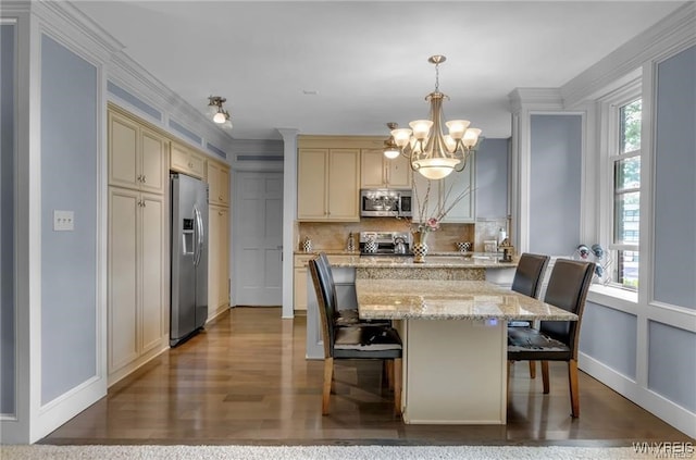 kitchen featuring a breakfast bar, appliances with stainless steel finishes, pendant lighting, and a healthy amount of sunlight