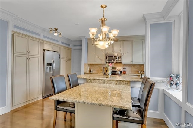 800 W Ferry St Unit 2Cc, Buffalo, NY 14222 - kitchen with appliances with stainless steel finishes, a breakfast bar area, tasteful backsplash, a chandelier, and pendant lighting