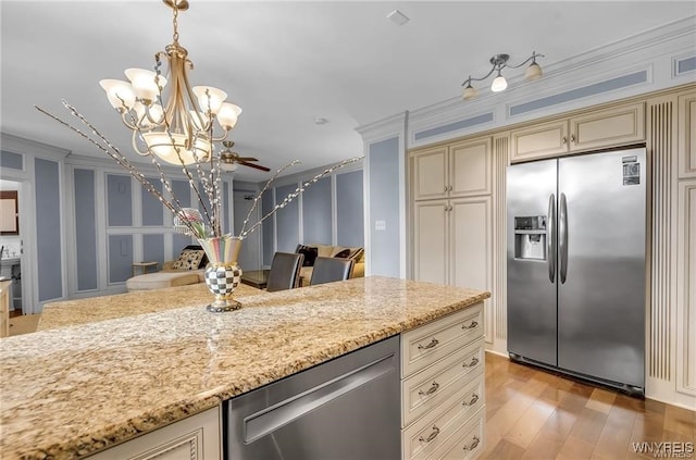 800 W Ferry St Unit 2Cc, Buffalo, NY 14222 - kitchen featuring appliances with stainless steel finishes, cream cabinetry, light stone counters, a chandelier, and a decorative wall