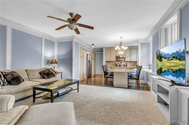 living room featuring ornamental molding, dark hardwood / wood-style floors, and ceiling fan with notable chandelier