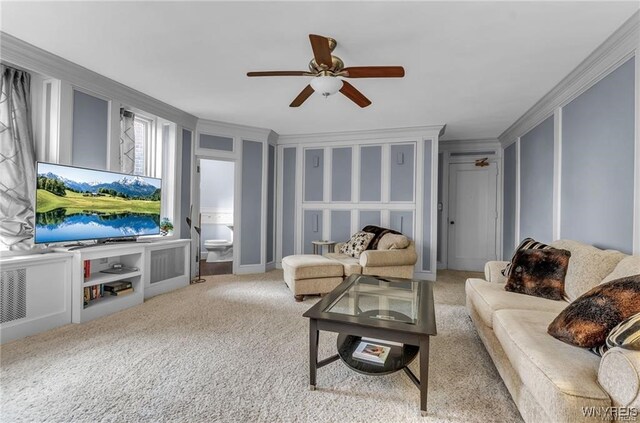 carpeted living room with crown molding and ceiling fan