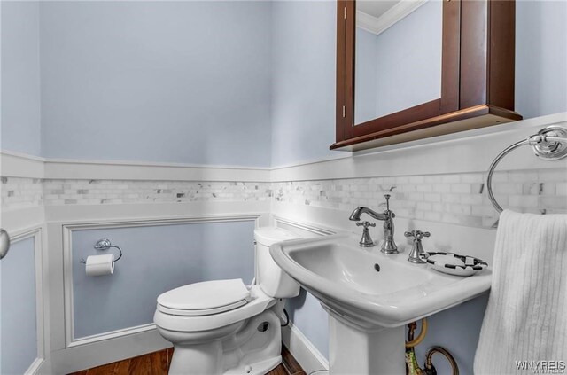 bathroom with toilet, tasteful backsplash, ornamental molding, and hardwood / wood-style floors