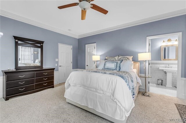 bedroom with ensuite bath, ornamental molding, sink, carpet floors, and ceiling fan