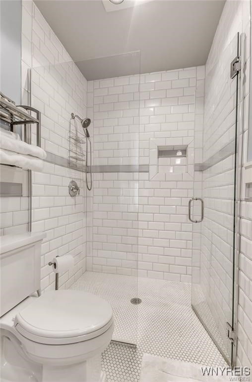 800 W Ferry St Unit 2Cc, Buffalo, NY 14222 - full bath featuring toilet, a shower stall, tile patterned floors, and tile walls