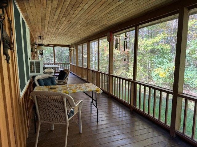 unfurnished sunroom featuring wooden ceiling and plenty of natural light