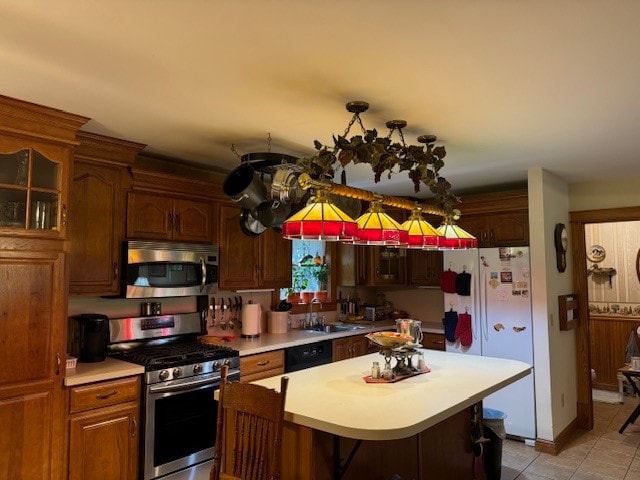 kitchen featuring light tile patterned floors, a kitchen breakfast bar, stainless steel appliances, sink, and a center island