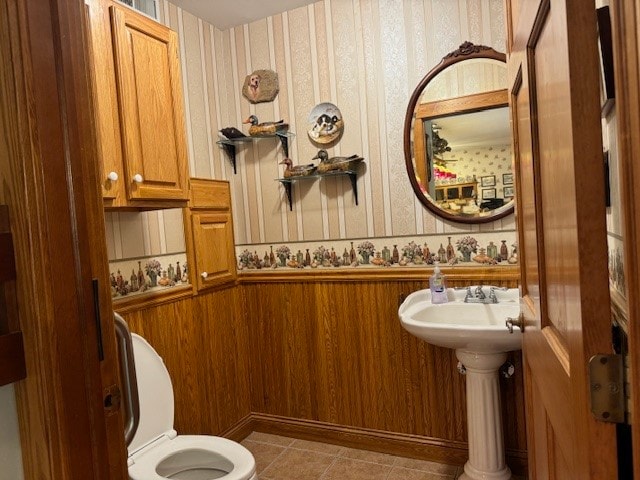 bathroom with toilet, tile patterned floors, and sink