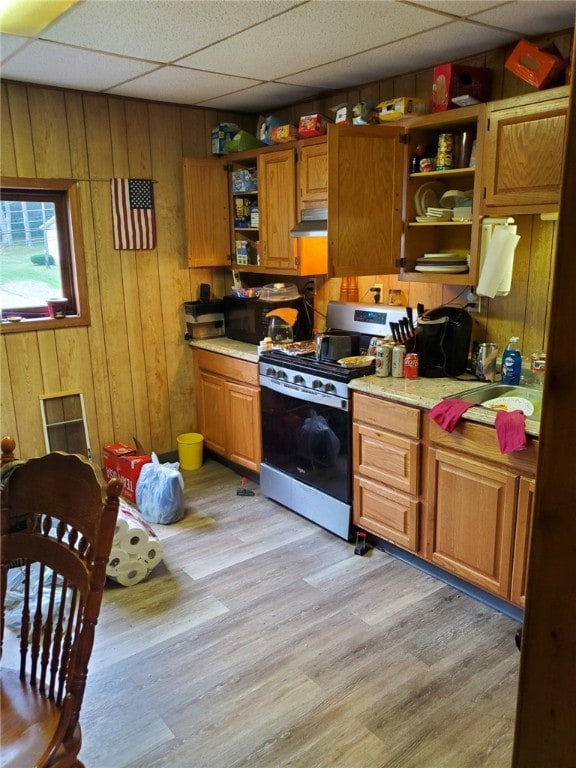 kitchen featuring a paneled ceiling, gas stove, and light hardwood / wood-style flooring