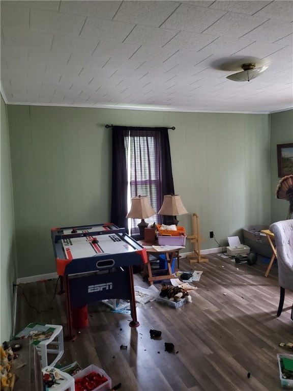 playroom featuring dark wood-type flooring, crown molding, and ceiling fan