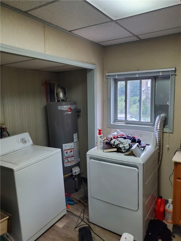 laundry room with light hardwood / wood-style flooring, washer and clothes dryer, and gas water heater