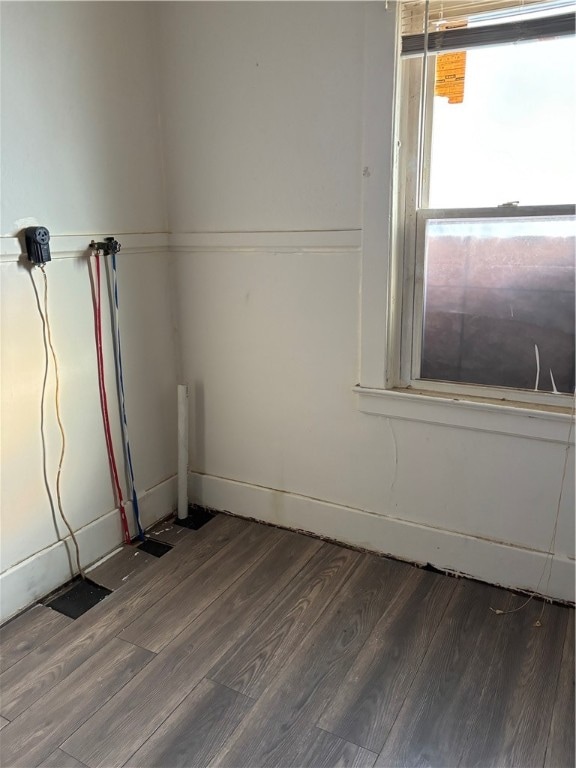 unfurnished room with dark wood-type flooring