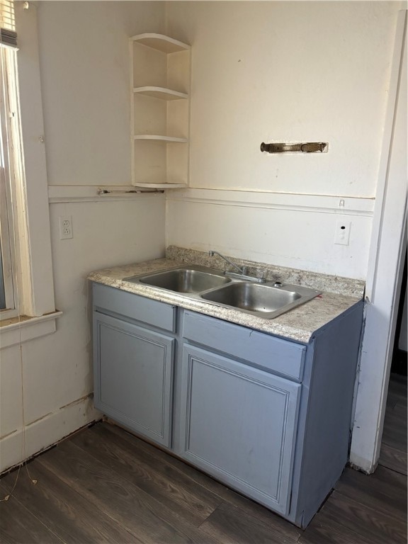 kitchen featuring dark hardwood / wood-style floors, blue cabinets, and sink