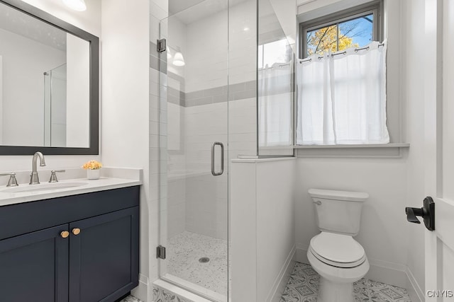 bathroom featuring tile patterned flooring, vanity, toilet, and a shower with door