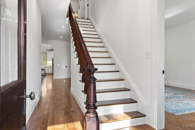 stairs featuring hardwood / wood-style flooring and crown molding