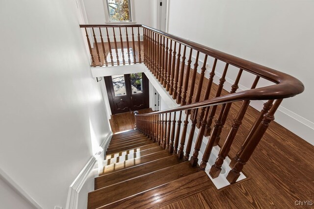 staircase featuring french doors and wood-type flooring