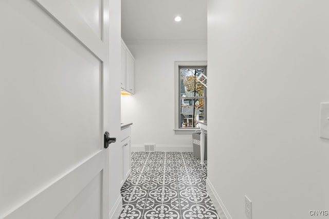 hall featuring light tile patterned floors and ornamental molding