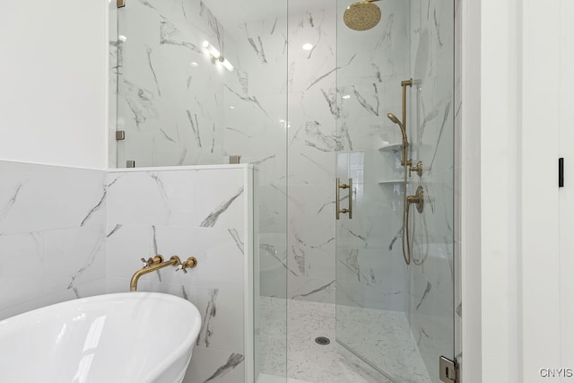 bathroom with tile walls and independent shower and bath