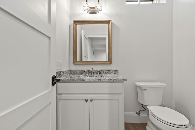 bathroom featuring hardwood / wood-style floors, vanity, and toilet