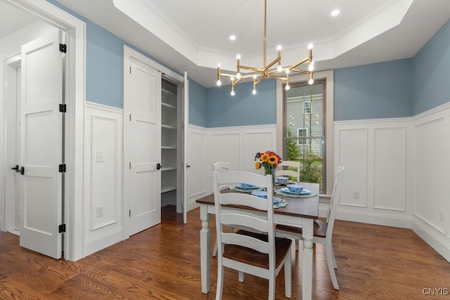 dining room featuring a chandelier, dark hardwood / wood-style flooring, ornamental molding, and a tray ceiling