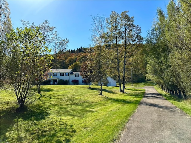 exterior space featuring aphalt driveway and a front yard