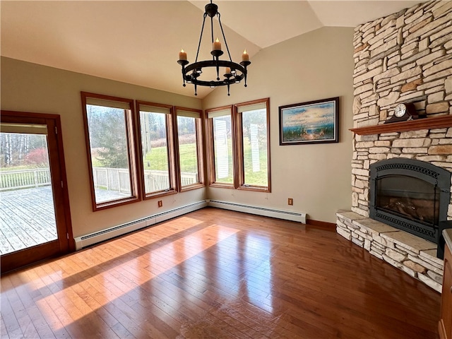 unfurnished living room featuring a baseboard heating unit, vaulted ceiling, an inviting chandelier, and hardwood / wood-style floors