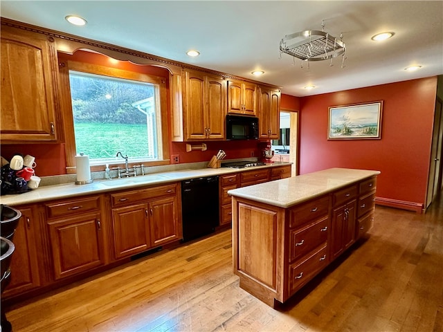 kitchen featuring light hardwood / wood-style floors, black appliances, sink, and a kitchen island