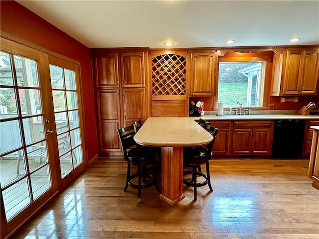 interior space with light wood-style floors, french doors, dishwasher, and a sink