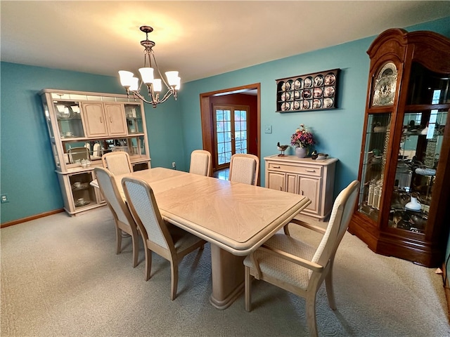 dining space with light carpet and an inviting chandelier