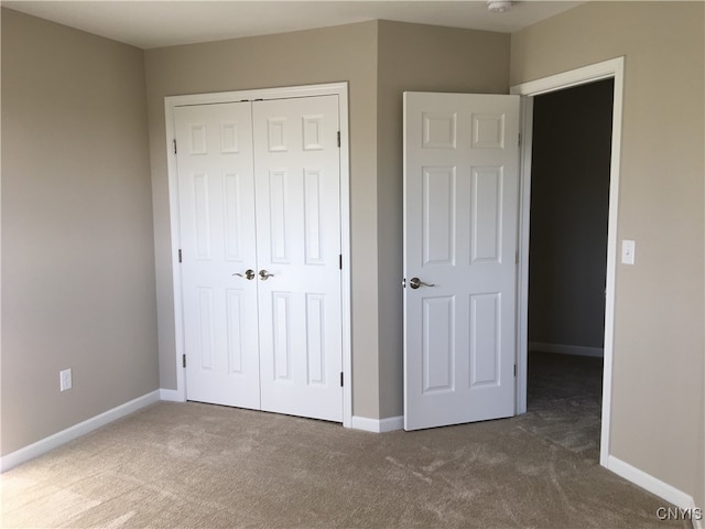 unfurnished bedroom featuring a closet and dark colored carpet