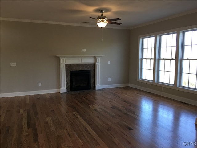 unfurnished living room with dark wood-type flooring, a healthy amount of sunlight, ornamental molding, and a fireplace