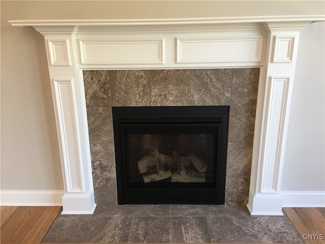 room details with hardwood / wood-style floors and a tile fireplace