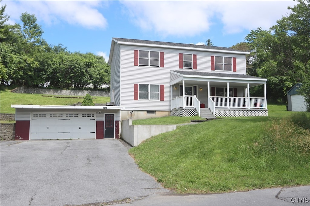 view of front facade featuring a porch, a front yard, and a garage