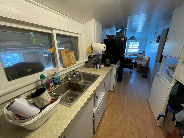 kitchen with sink, hardwood / wood-style floors, and electric stove