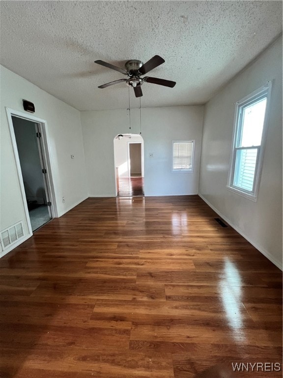 unfurnished room featuring dark hardwood / wood-style flooring, a textured ceiling, and ceiling fan