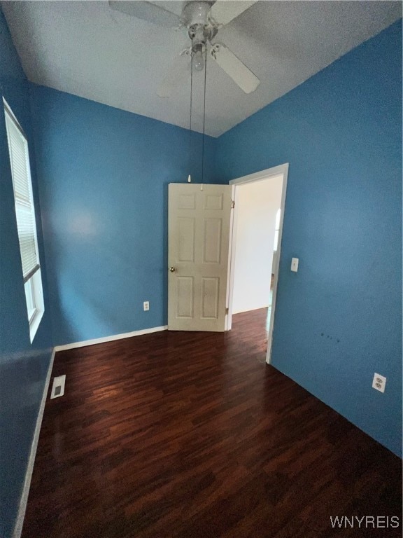 empty room with dark wood-type flooring, a textured ceiling, and ceiling fan