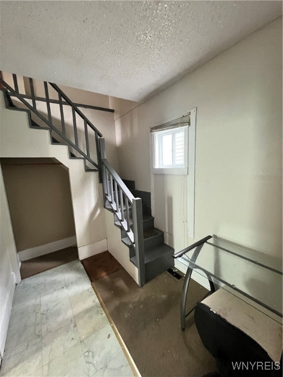 stairway with a textured ceiling