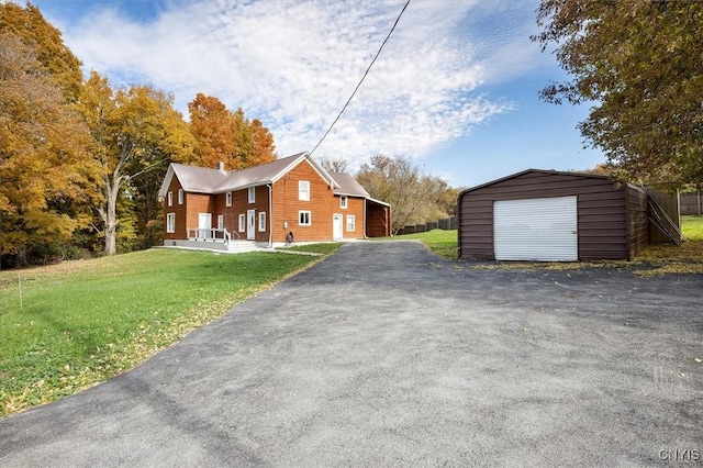 view of front facade featuring a front lawn, a garage, and an outbuilding