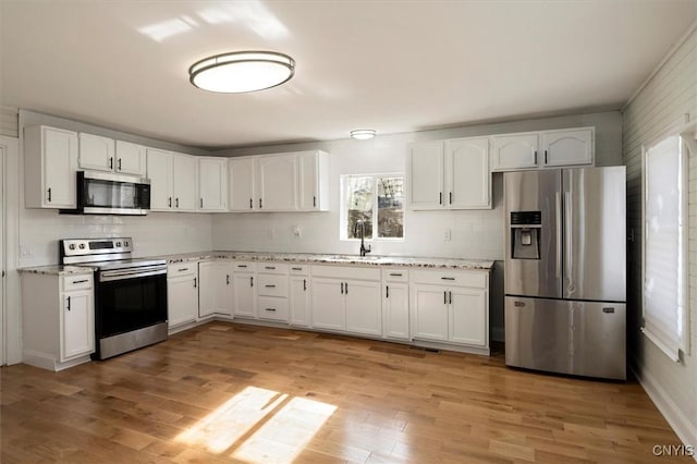 kitchen featuring sink, white cabinetry, appliances with stainless steel finishes, and tasteful backsplash