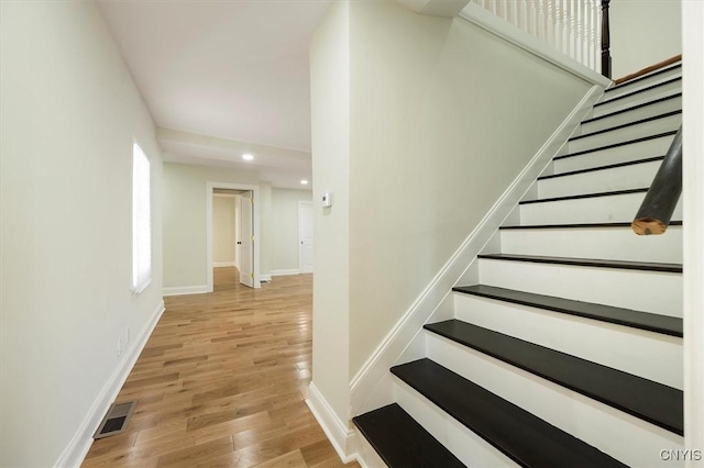 stairway with hardwood / wood-style floors