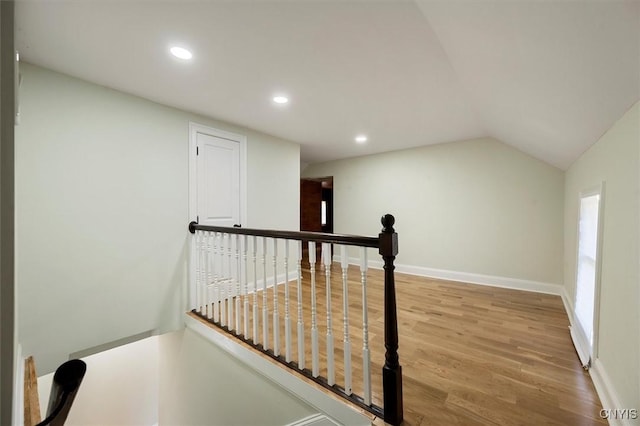 staircase featuring vaulted ceiling and wood-type flooring