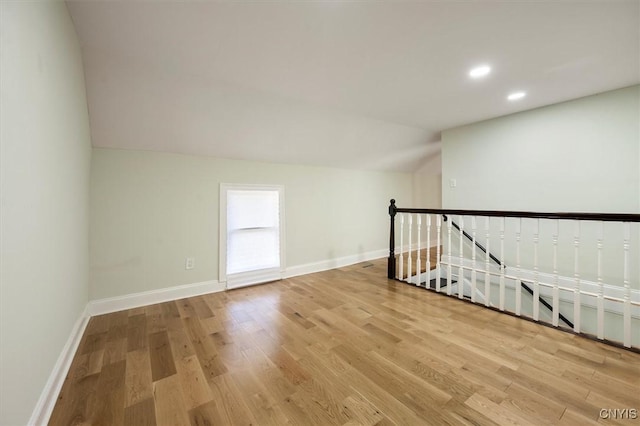 spare room with lofted ceiling and light hardwood / wood-style floors