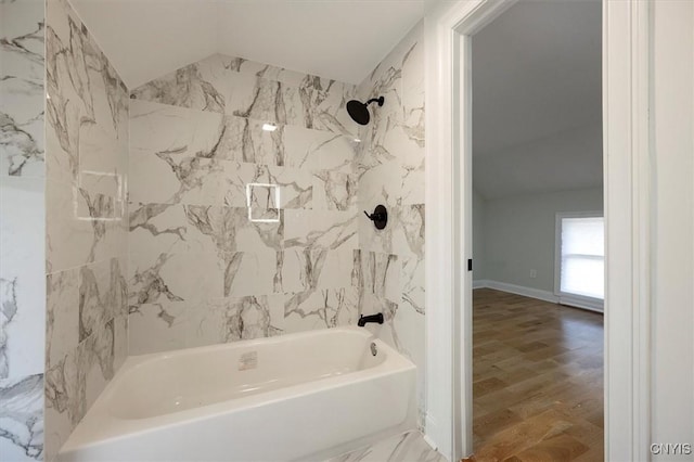 bathroom with hardwood / wood-style floors and tiled shower / bath