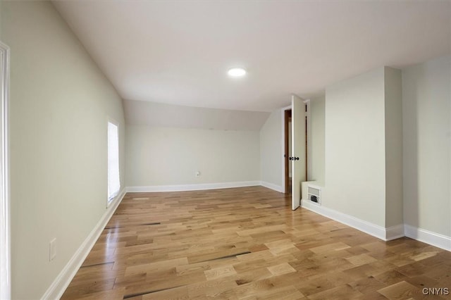 empty room with lofted ceiling and light wood-type flooring