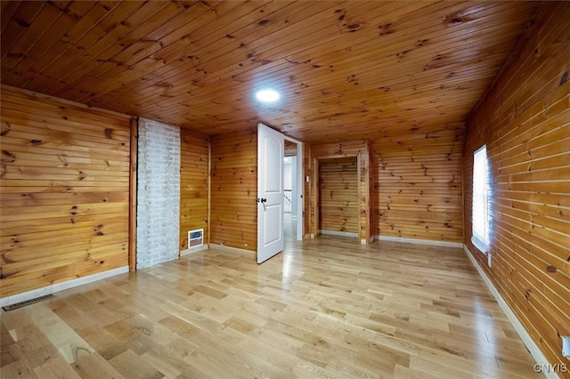 additional living space with light hardwood / wood-style flooring, wood ceiling, and wooden walls